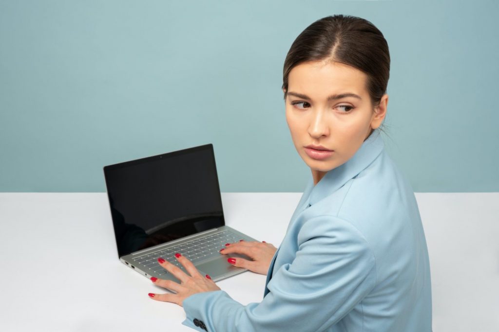 worried woman looking over shoulder at computer